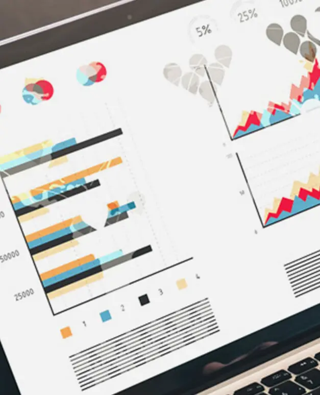 Laptop-Bildschirm zeigt bunte Balken- und Liniendiagramme sowie Prozentangaben zu Statistikdaten