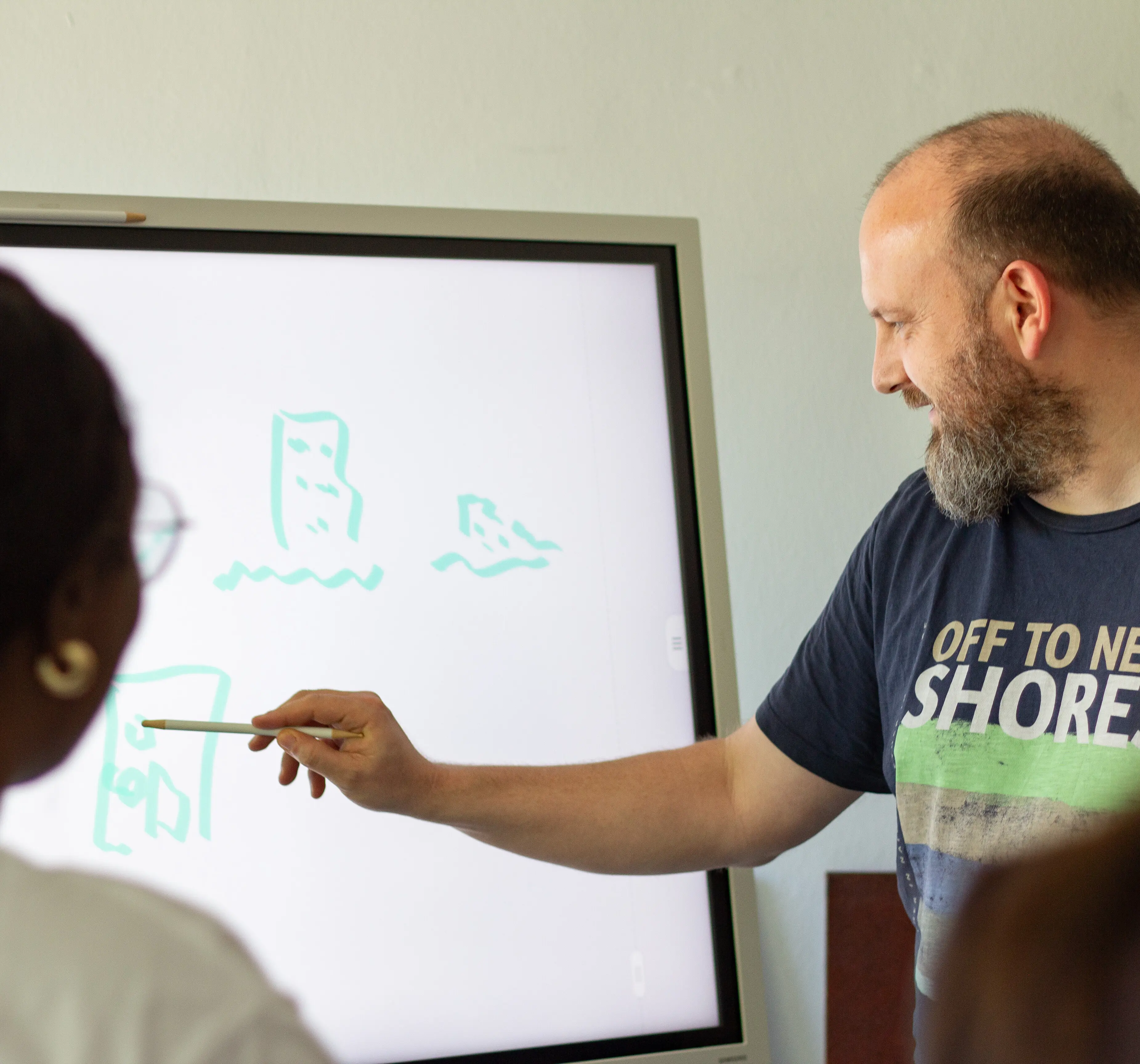 Mann erklärt mit Stift an digitalem Whiteboard mit Skizzen, zweite Person schaut zu – Workshop Digitalagentur conlabz Koblenz