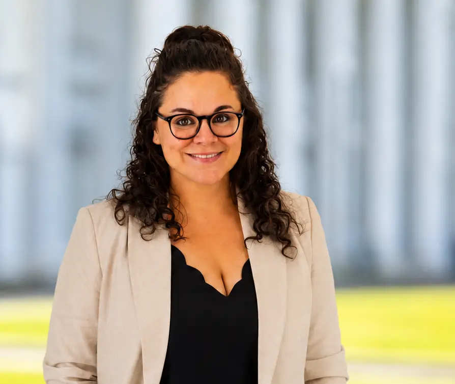 Porträt einer lächelnden Frau mit Brille im Business-Blazer