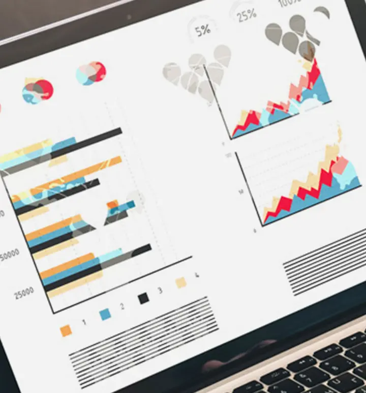 Laptop-Bildschirm zeigt bunte Balken- und Liniendiagramme sowie Prozentangaben zu Statistikdaten